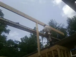 Carpenter setting a ridge beam over a new addition frame — Ice Dam Removal by Roofing Brothers in Calumet