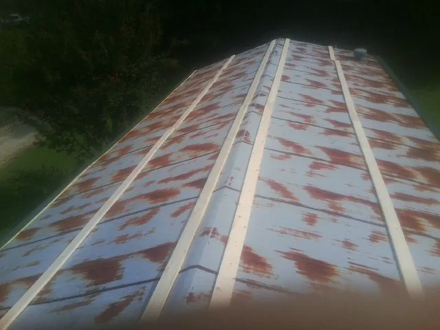 Rusted metal roof panels with new wood purlins before replacement — Storm Damage Roof Repair in Calumet by Roofing Brothers