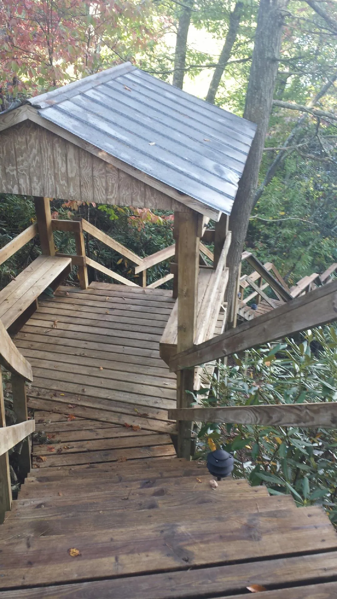 Metal roofed shelter over wooden steps on a wooded walkway — Skylight Repair & Installation work by our crew in Calumet
