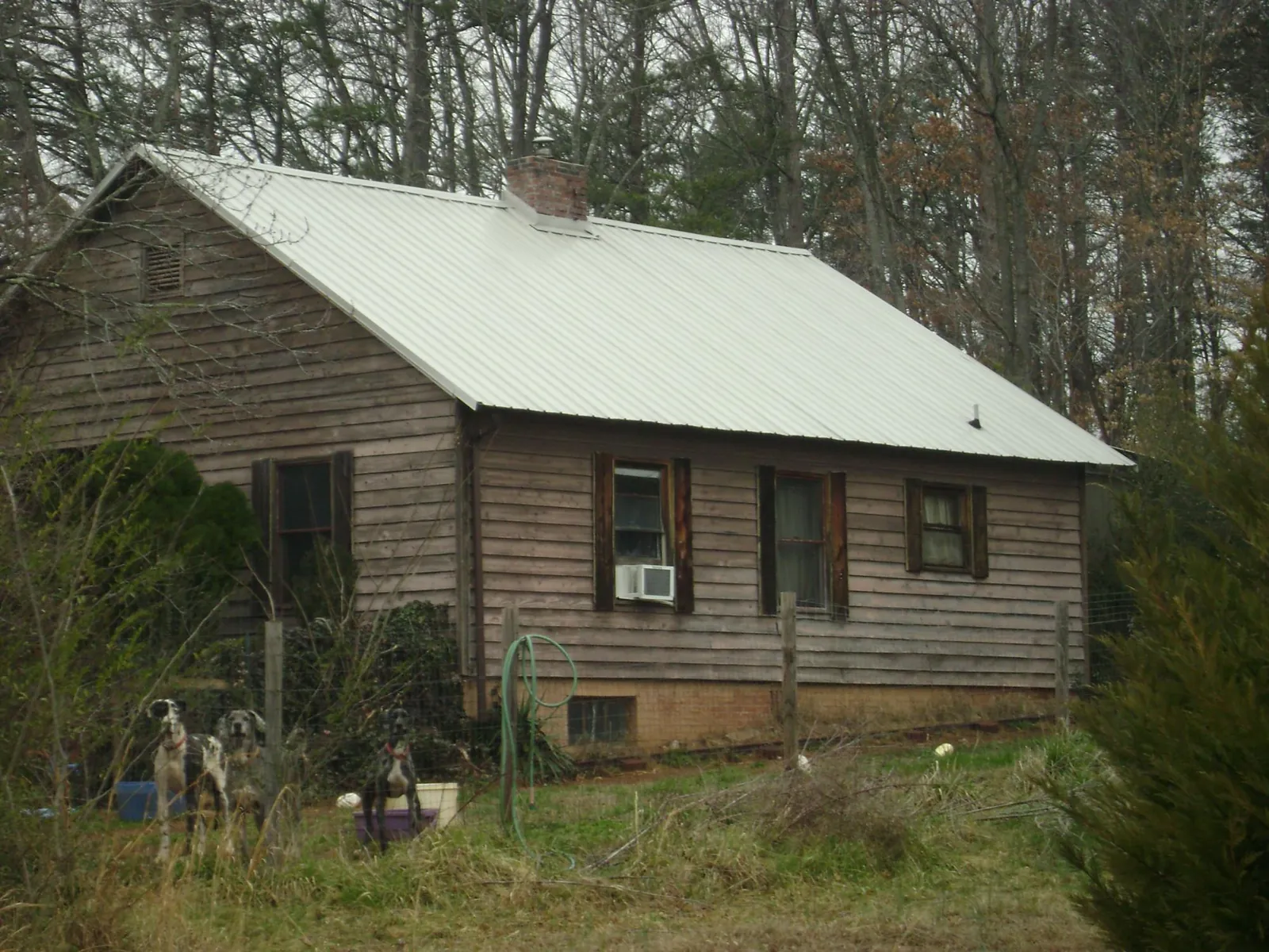 White metal roof on an old wood sided farmhouse, from a Metal Roof Installation job in Calumet